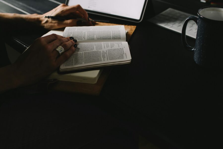 Person reading finance book notebook coffee