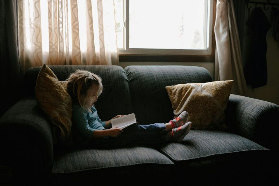 Babysitter reading book children sofa
