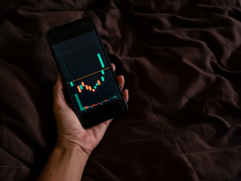 Person reading stock market news smartphone