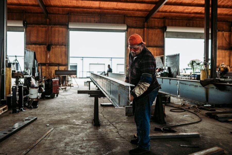 Small factory worker checking metal inventory