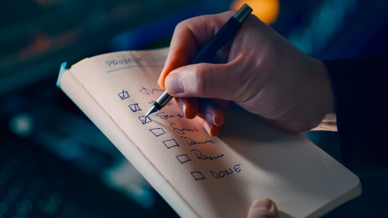 Closeup hands writing investment plan checklist