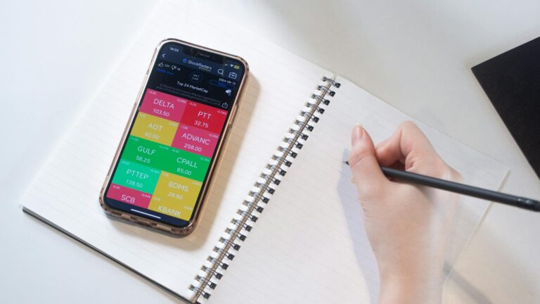Hand writing checklist notebook smartphone banking app open