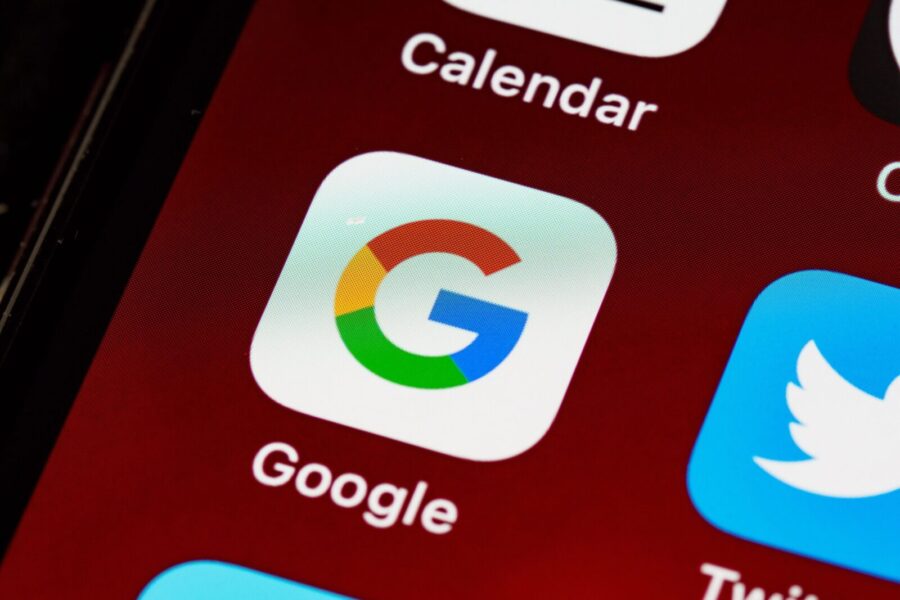 Macro view of a smartphone displaying Google and other app icons on the home screen.